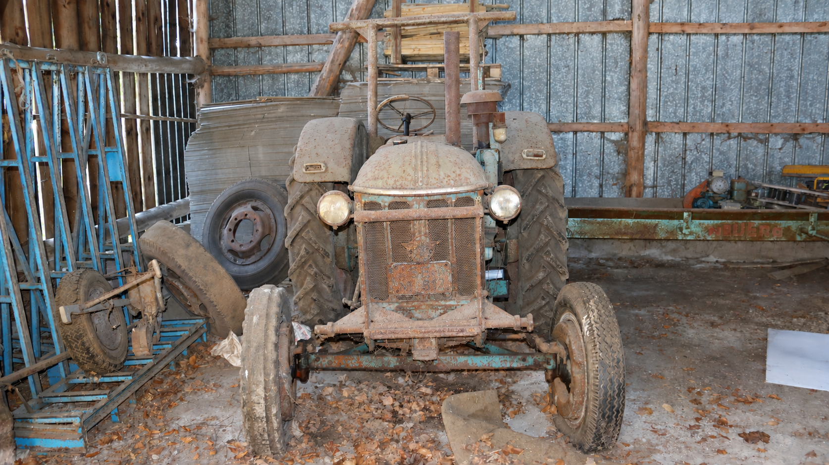 Verrosteter Traktor im verlassenen Schuppen.png