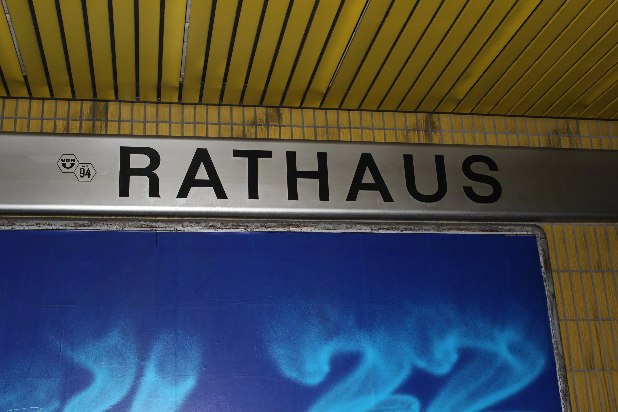 Schilder mit der Aufschrift 'Rathaus' auf einer Wand in einer U-Bahn-Station.