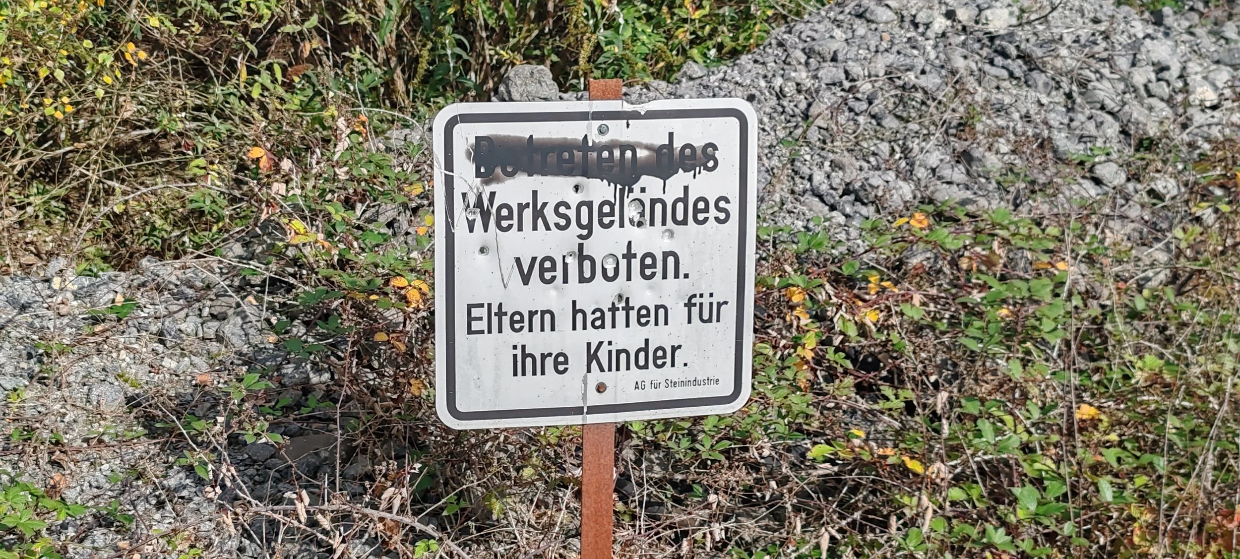 Ein Schild am Straßenrand, das das Betreten des Baustellenbereichs verbietet, mit einem Zusatz, dass Eltern für ihre Kinder haften.