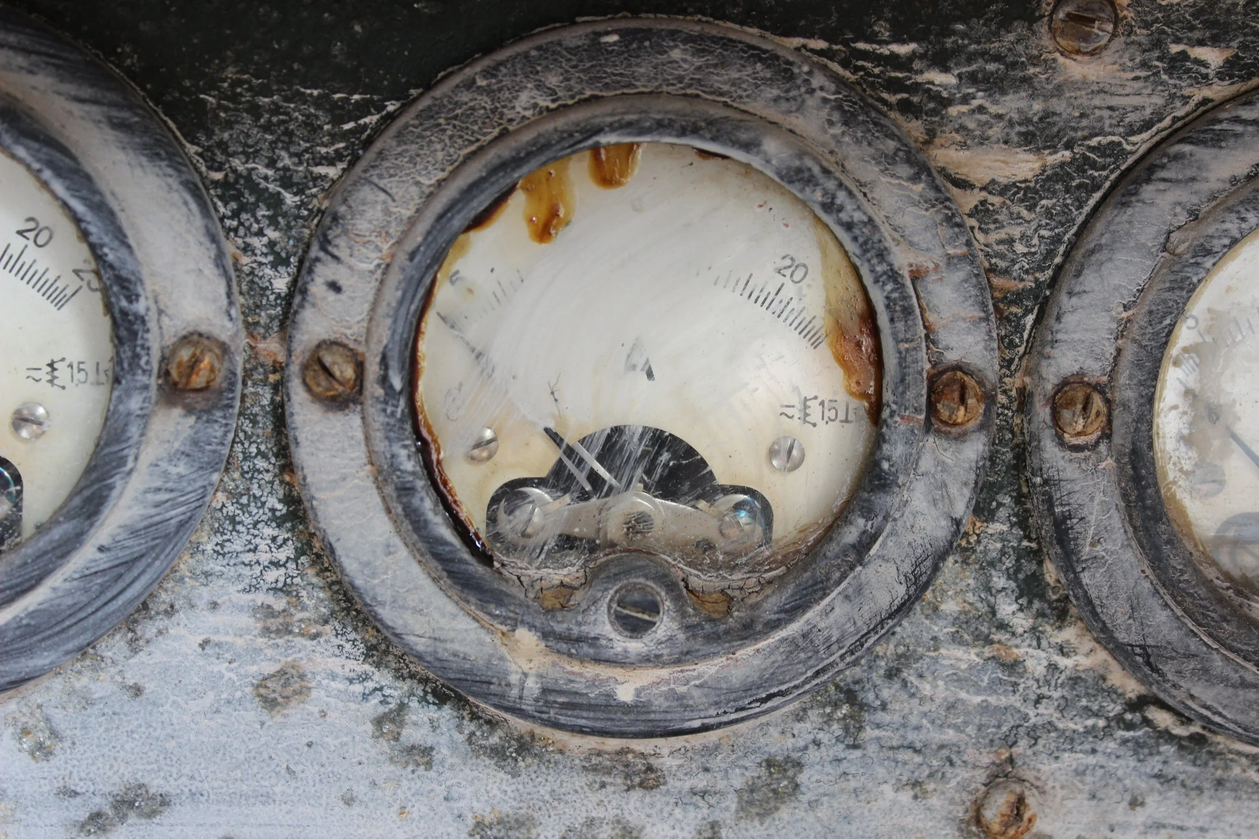Alte, verrostete Messgerät-Drehanzeigen mit beschädigtem Zifferblatt, das durch Rost und Verschmutzung verunreinigt ist.