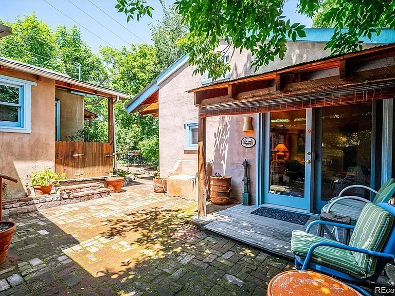 Exterior view of a Santa Fe style cottage with the courtayrd.