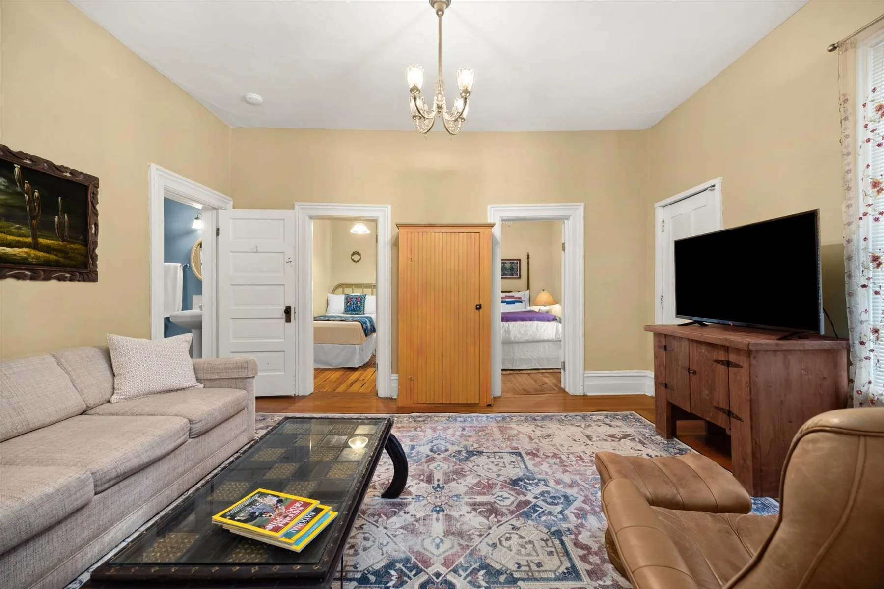 Looking across a living room at two bedrooms with open doors.