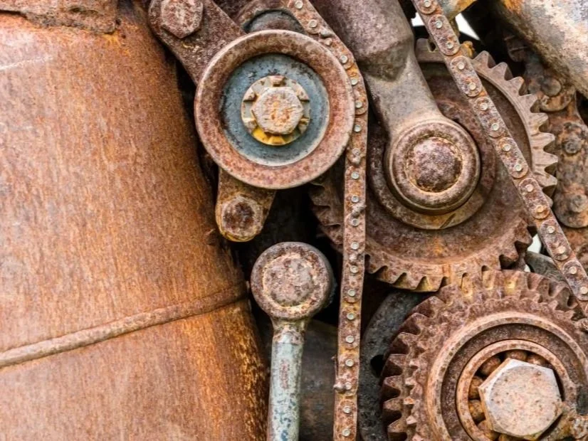 Close-up of rusted mechanical gears and chains on a machine that could be cleaned with dustless blasting by Ready Surface.