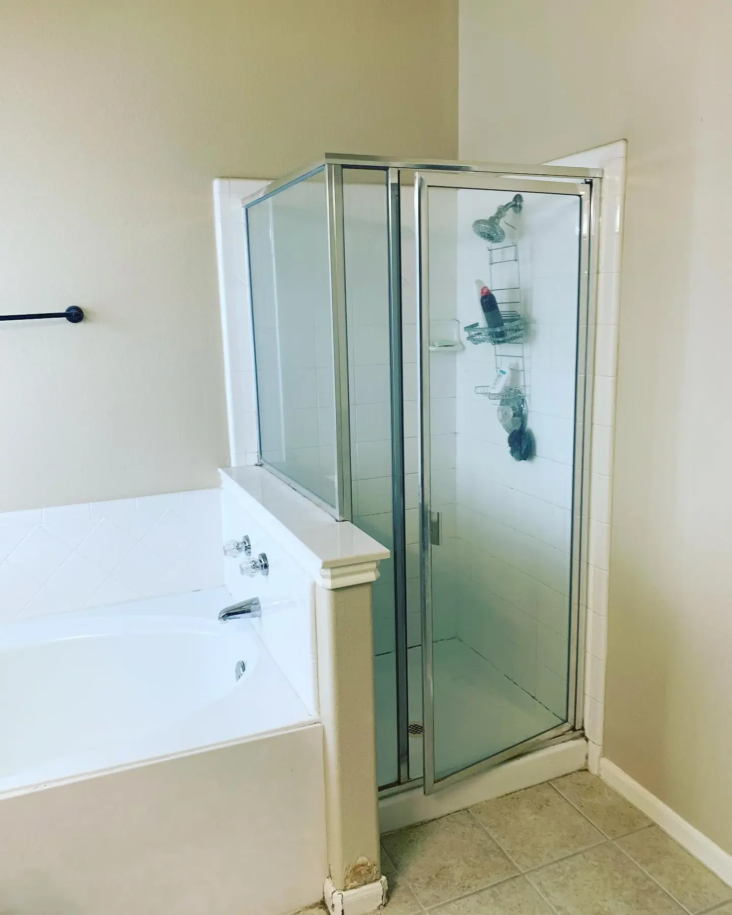 Bathroom corner with a bathtub and a glass shower stall.