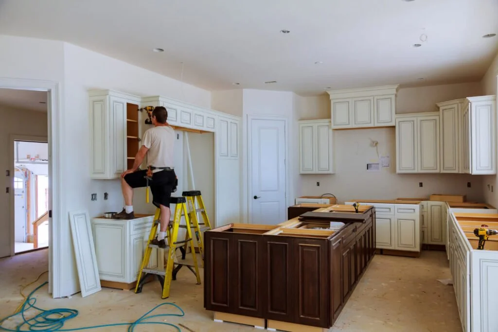 Construction workers installing kitchen cabinets in a new home.