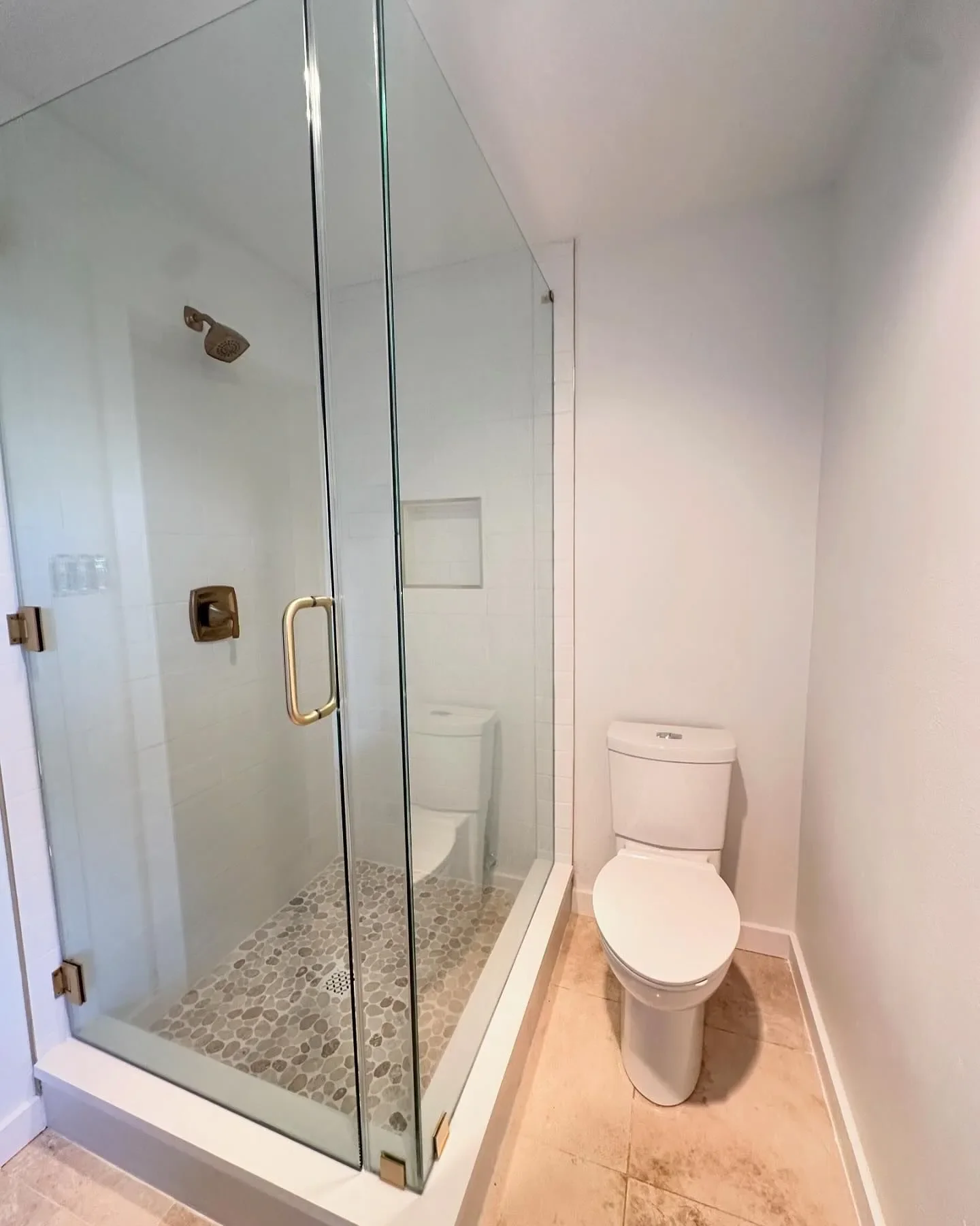 Bathroom with a glass shower enclosure and a toilet next to it.