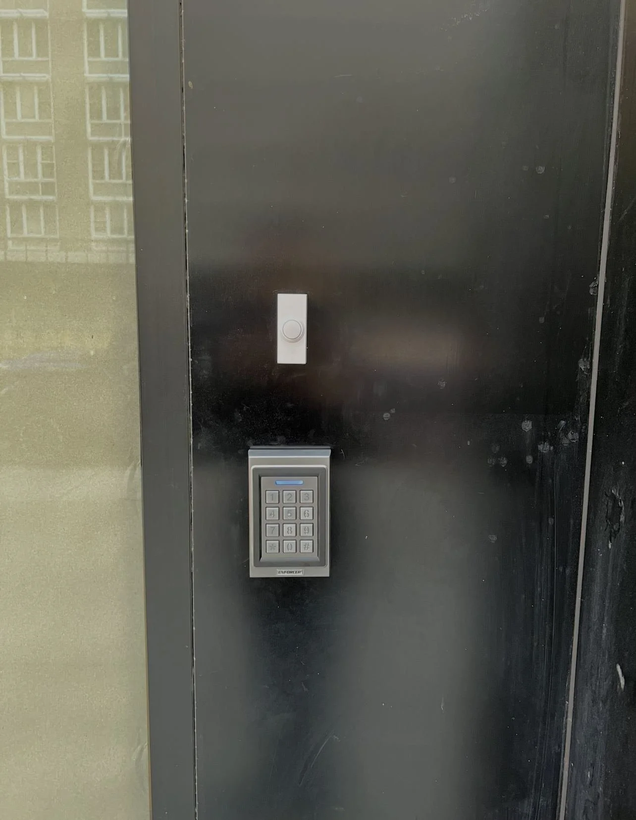 Seco-Larm Bluetooth keypad access control installed at the entrance of a retail store in Manhattan.