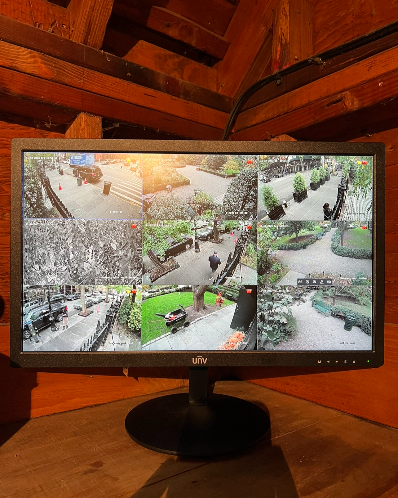 Security monitor displaying multiple CCTV camera feeds of an outdoor park and street scenes in NYC.