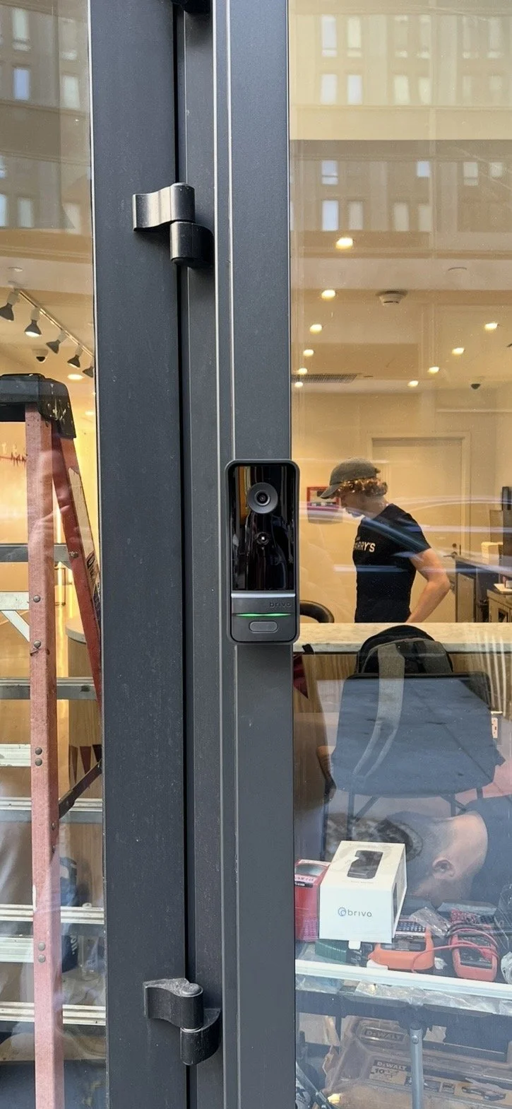 Commercial building glass entrance doors integrated with a secure video intercom and entry system.