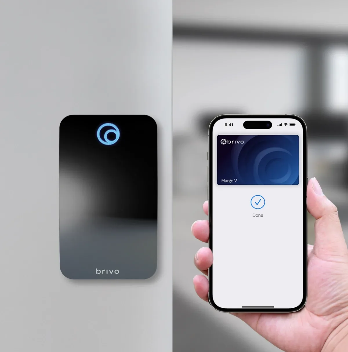 A person holding a smartphone with a digital key for a Brivo access control system displayed on the screen. The electronic lock on the door shows the Brivo logo.
