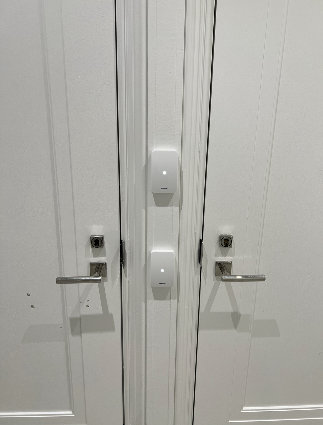 Secure commercial double door entry system with integrated access control sensors.