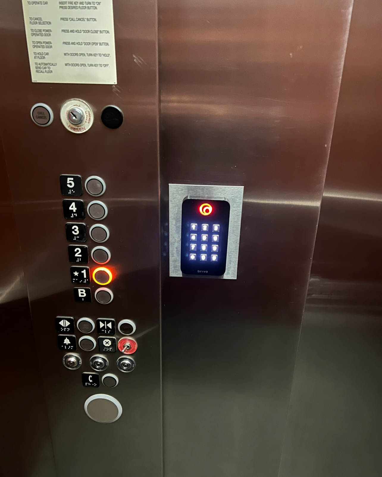 Inside an elevator with control panel buttons, a keypad, and an intercom.