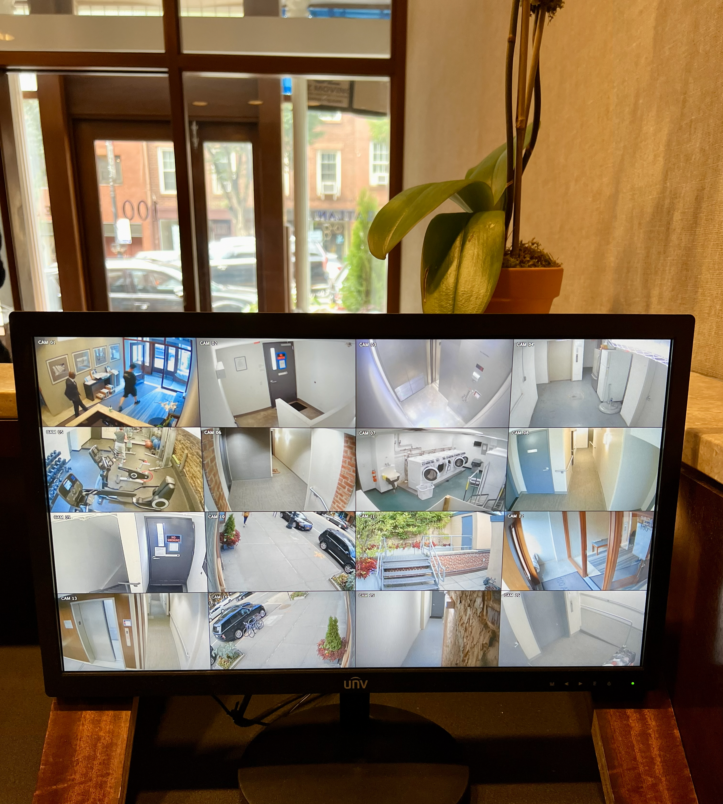 Multi-camera video surveillance monitor showing live security footage of property entrances and hallways.