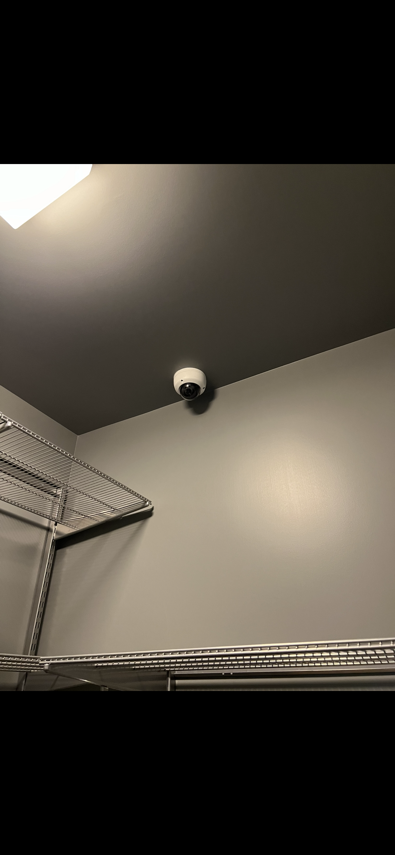 Security camera installed inside package room for 24/7 monitoring and theft prevention.