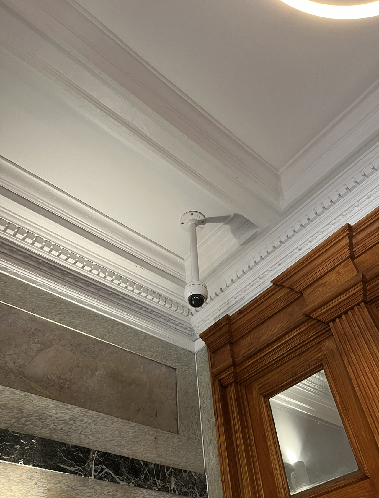 Indoor security camera installed on a drop ceiling in residential building for optimal coverage in NYC - Impera Security Systems. 