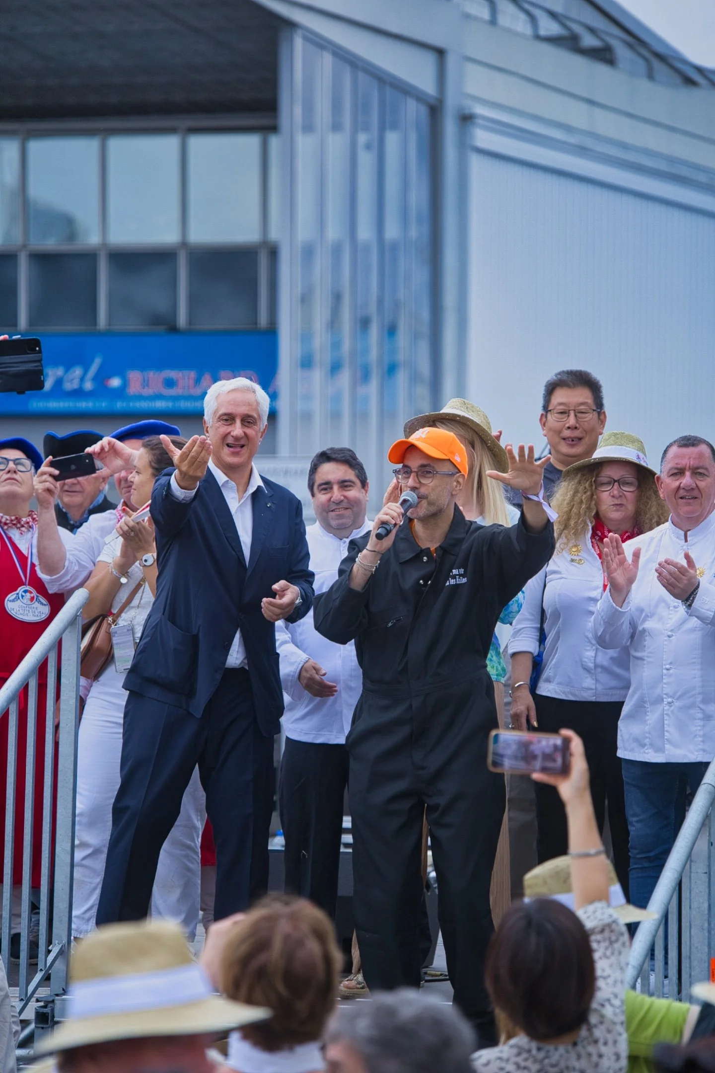 Groupe de personnes, dont un homme qui parle dans un micro et un autre qui semble applaudir, lors du Brungis au marché de Rungis.