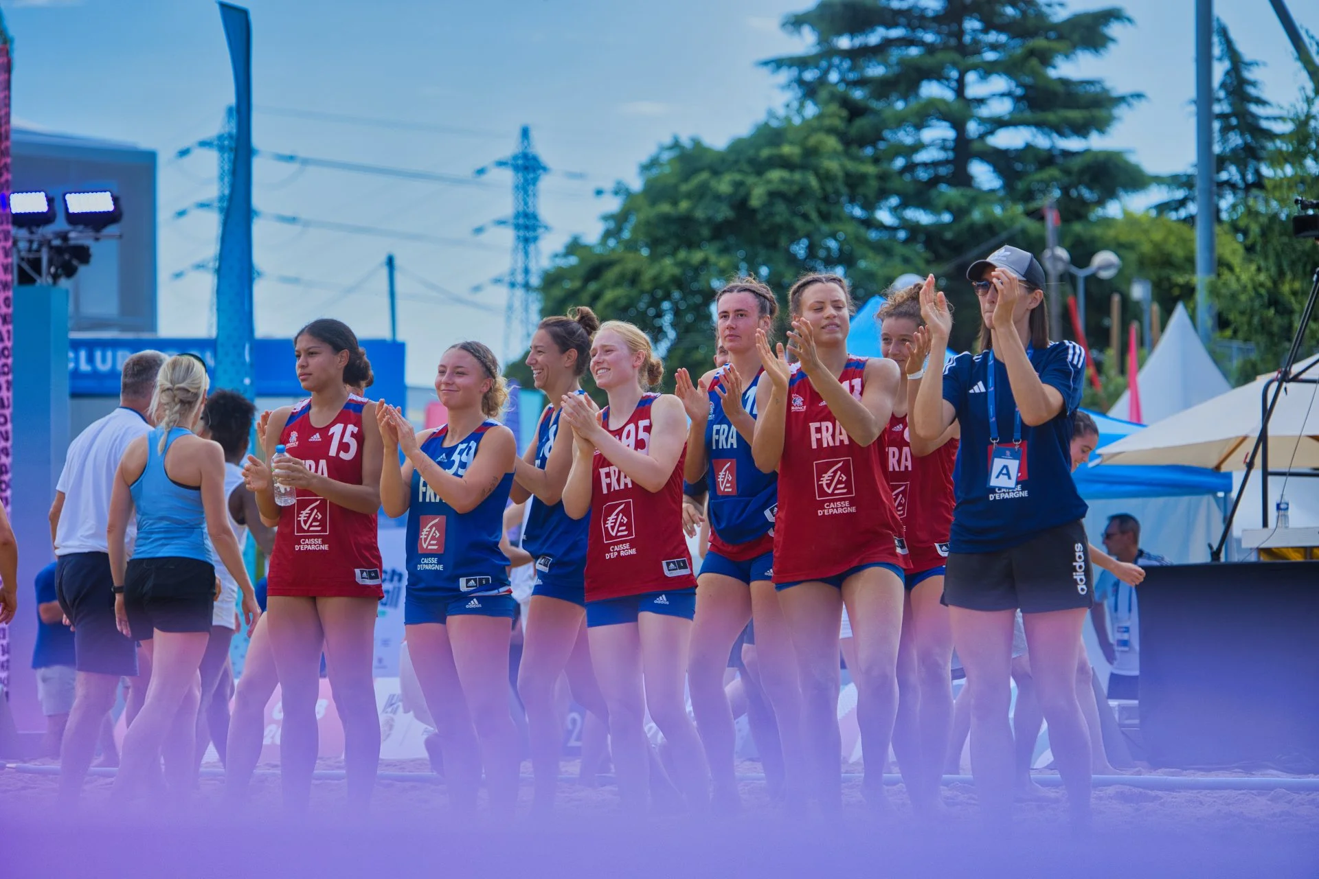 Une équipe féminine de beach-volley française applaudissant lors d'une compétition