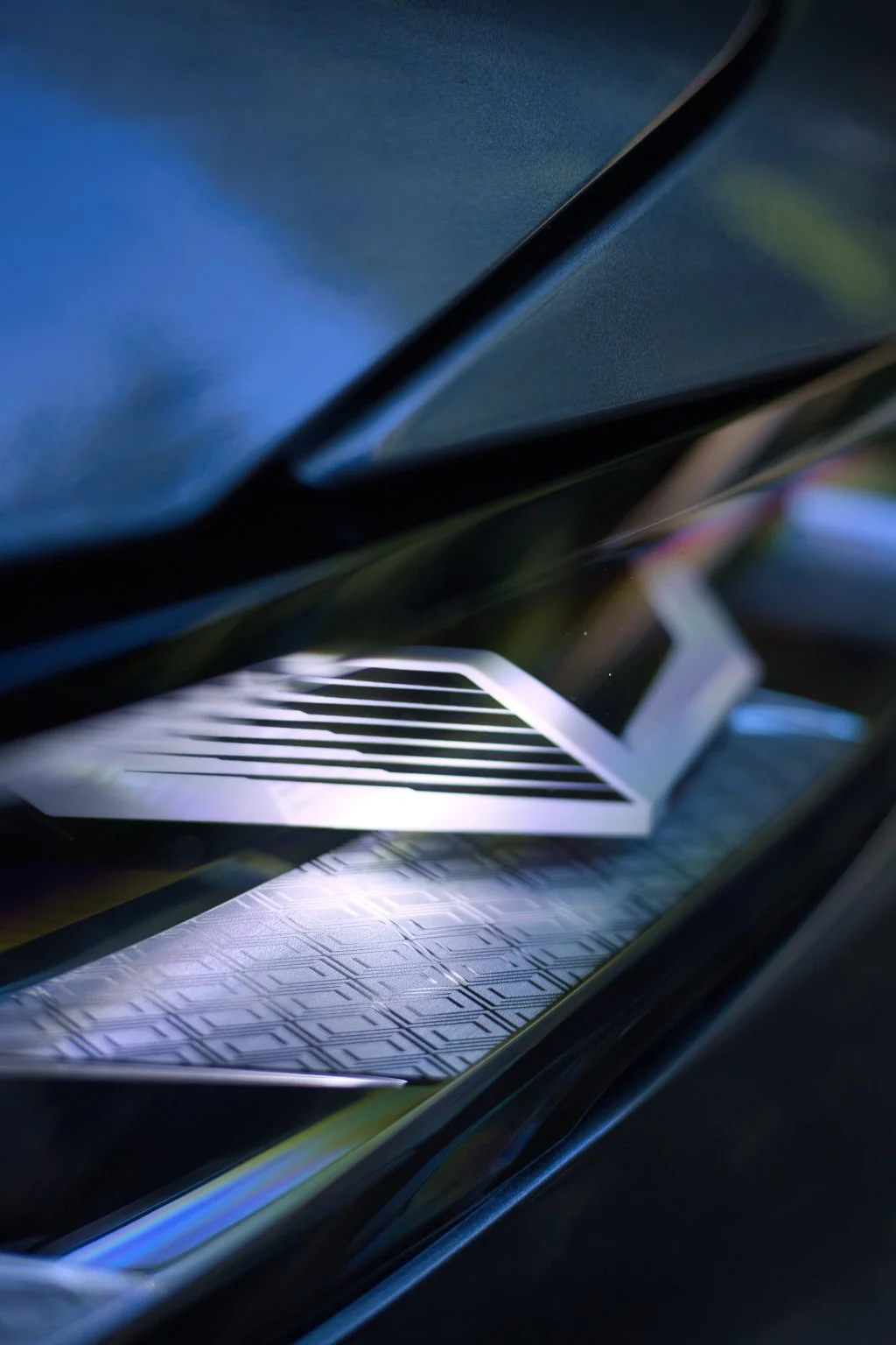 Une vue rapprochée de la grille de ventilation d'une voiture de luxe avec des finitions modernes en noir et blanc, sous un éclairage subtil. Renault Austral e-tech 200