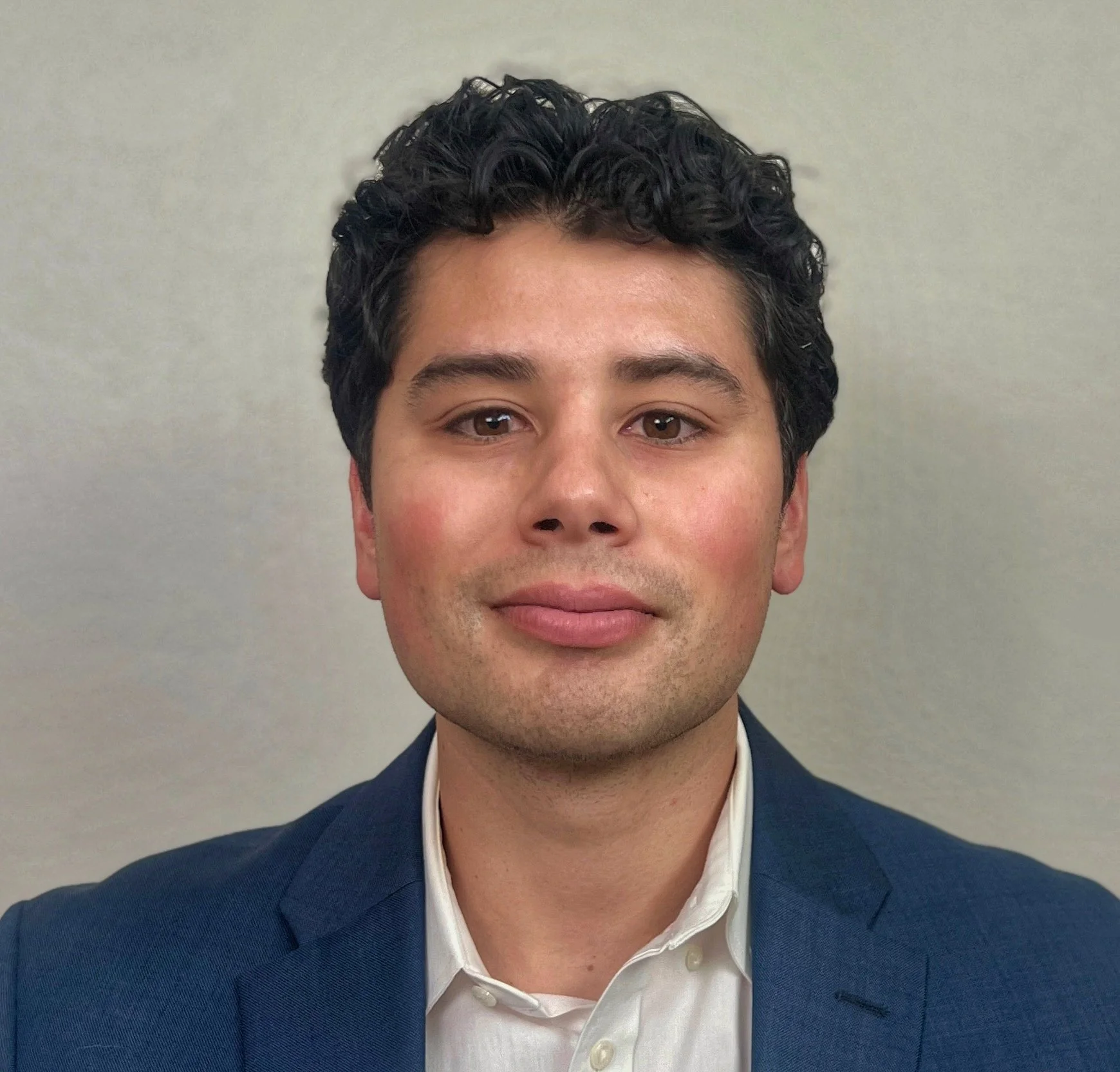Portrait of Luis Lopez in a navy jacket and white shirt.