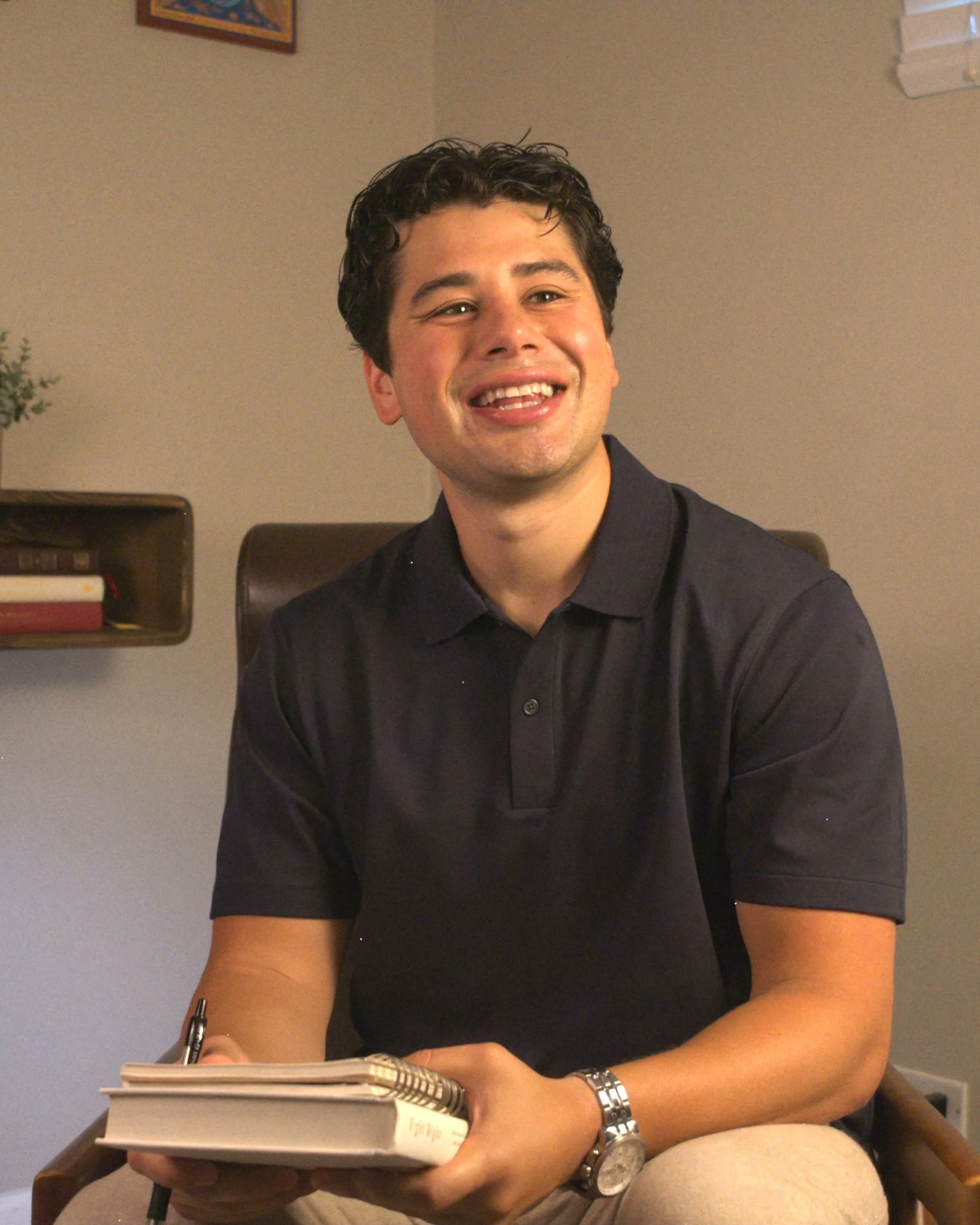 Luis Lopez seated at a table with a notebook and pen.