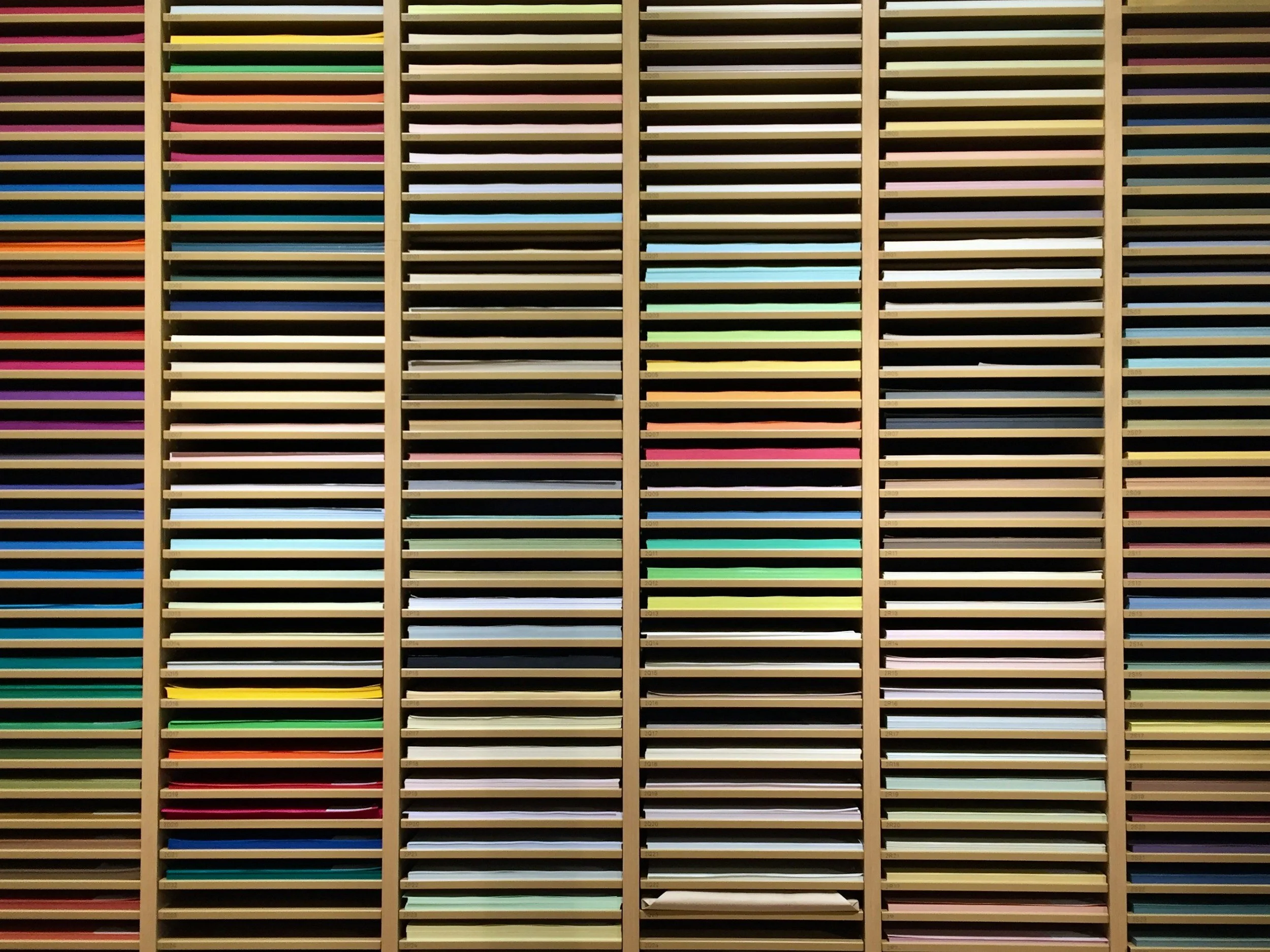 Colorful wall of horizontal slats in various shades of colors arranged in vertical columns.