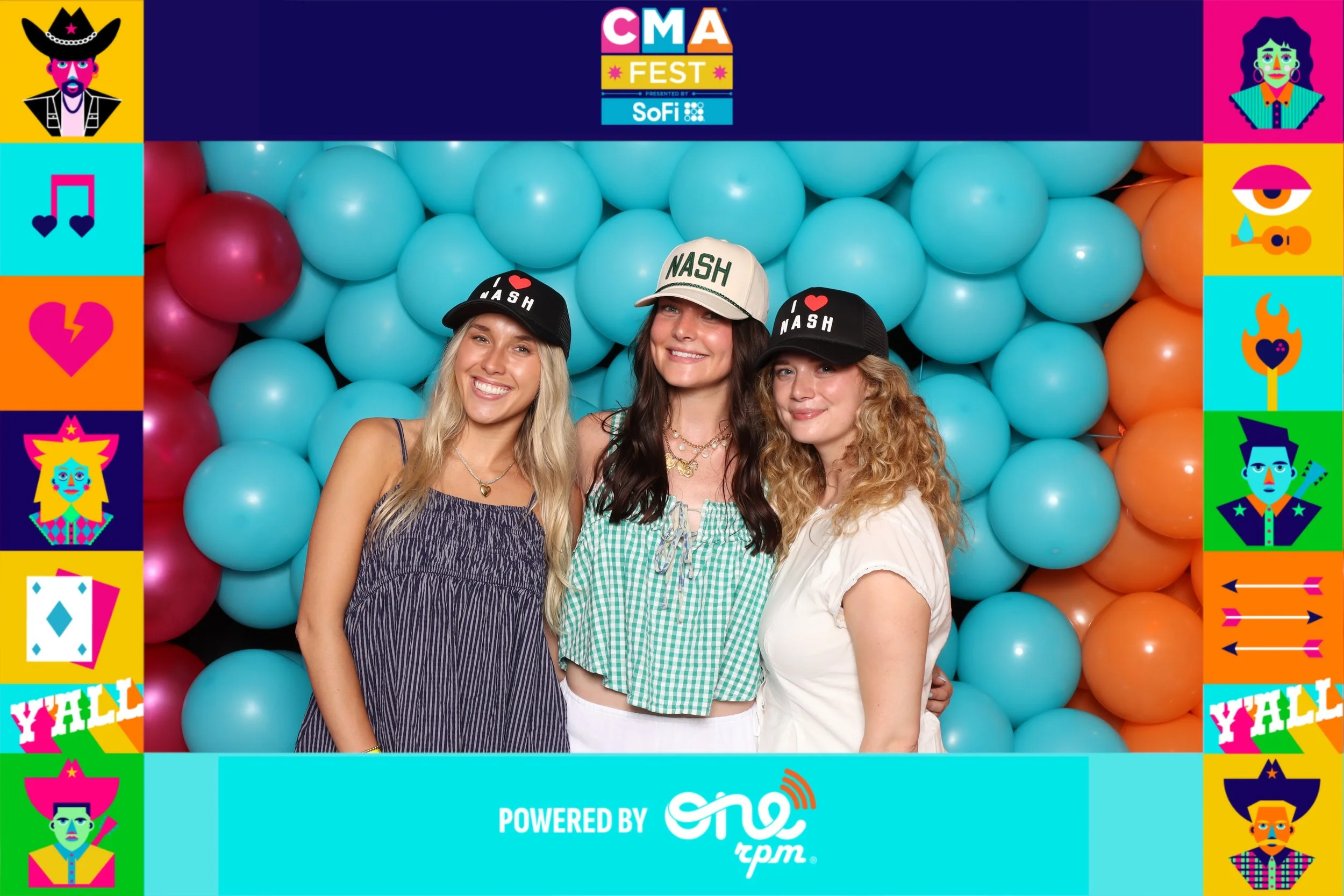 Three women smiling at the camera in front of a turquoise balloon backdrop, wearing hats that say 'I love Nash,' at the CMA Fest event.