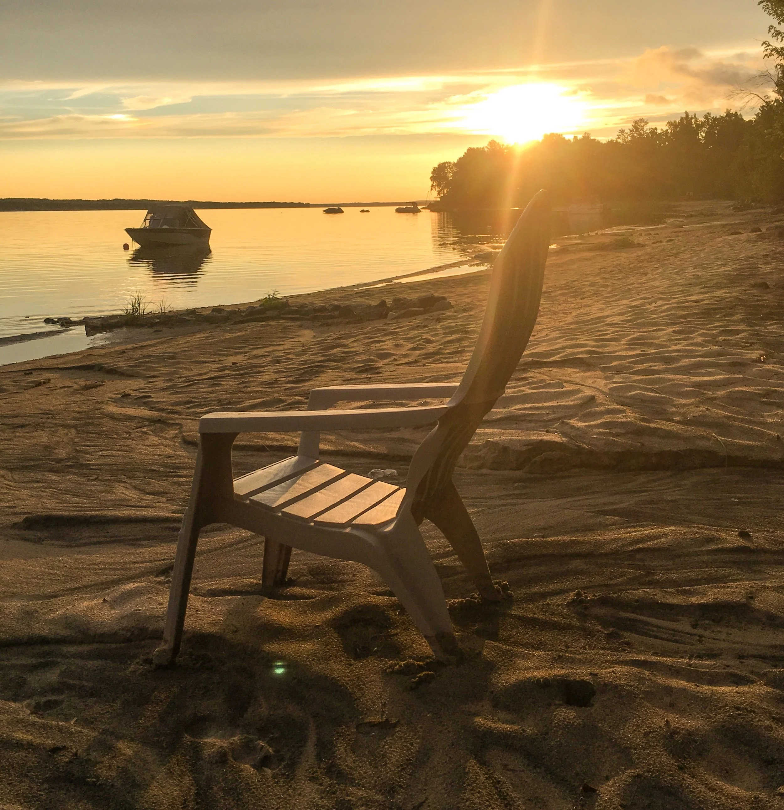 Sunset over the lake and a quiet sandy shore