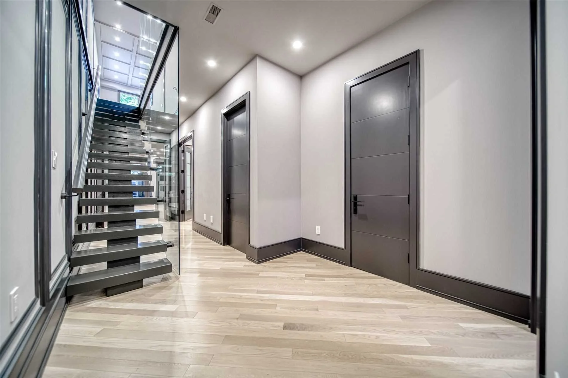 Modern interior with staircase and gray doors in a hallway.