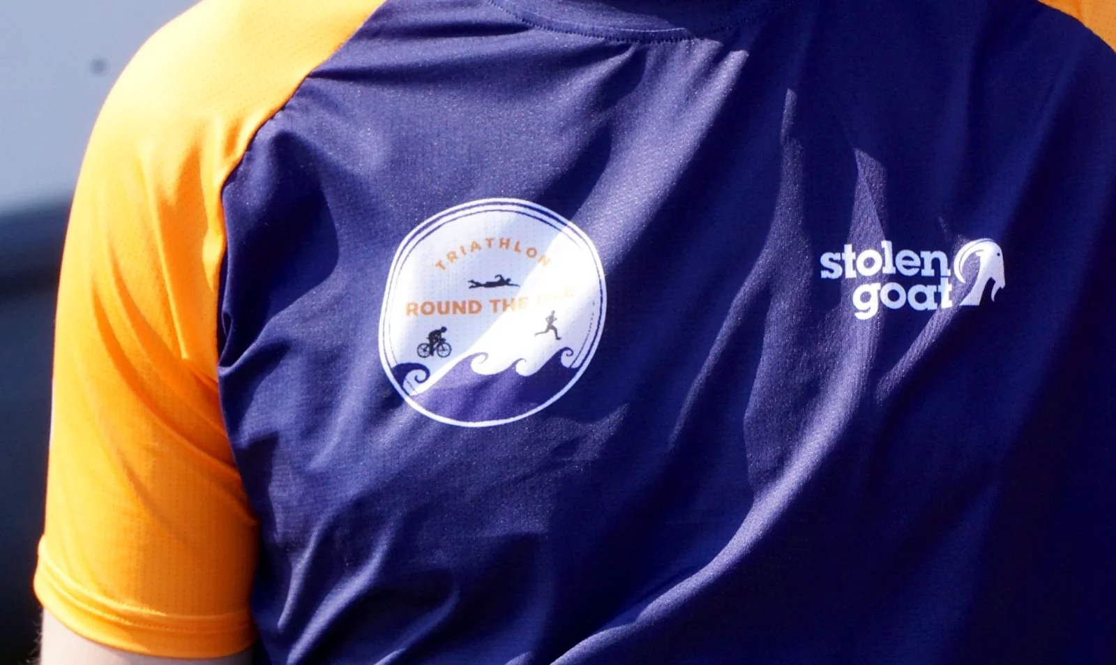 Close-up of a sports jersey with logos for triathlon event and sponsors.