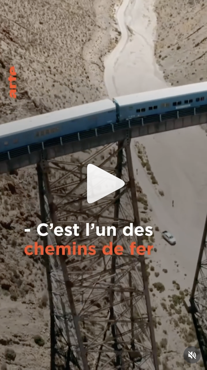Documentaire 'danger sur les rails' diffusé par ARTE France. Un train bleu passant sur un viaduc en acier dans un paysage désertique avec un chemin de fer en contrebas.