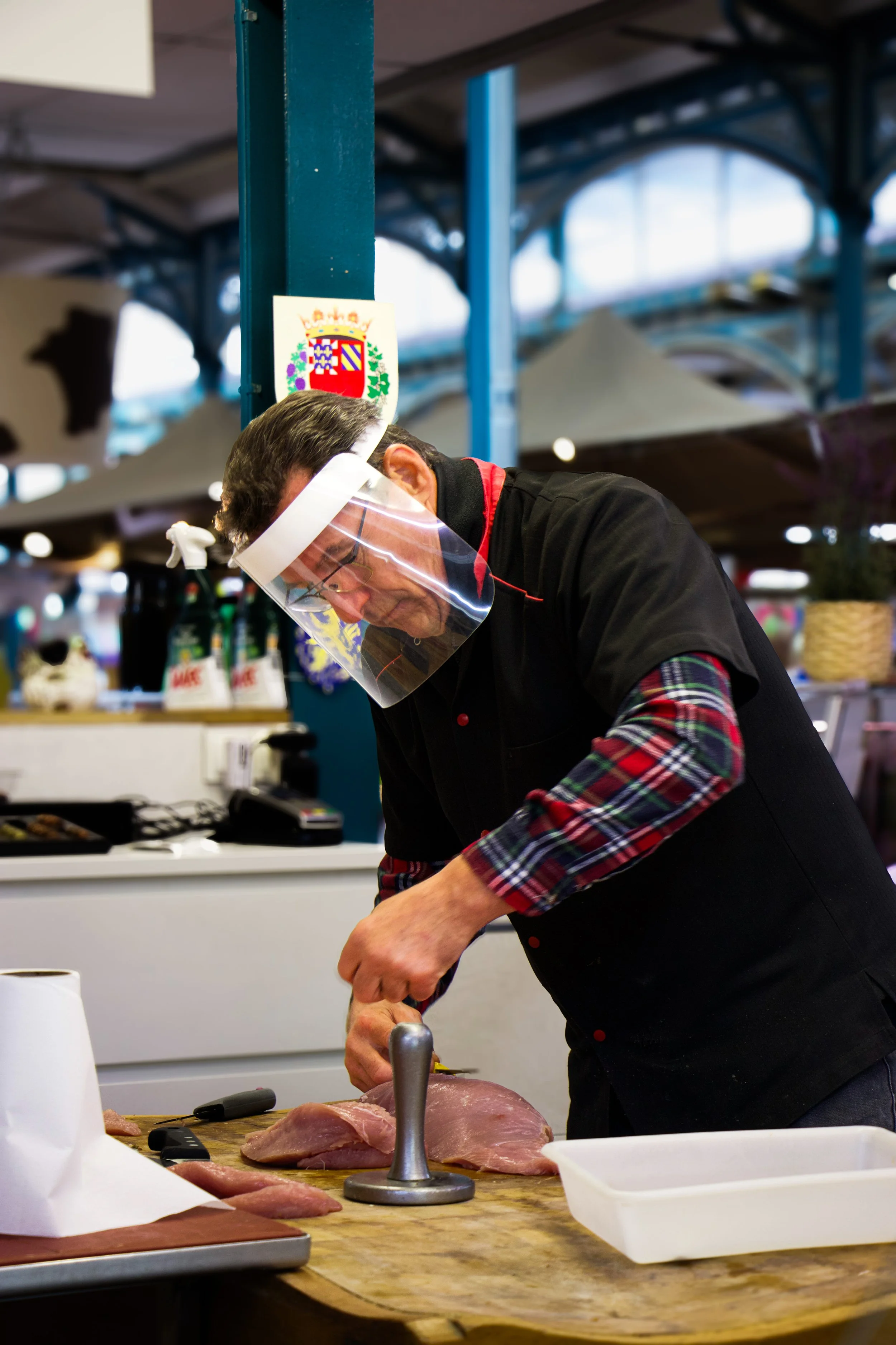 Photographie d'un Boucher en action au marché des halles de Dijon durant le covid19 