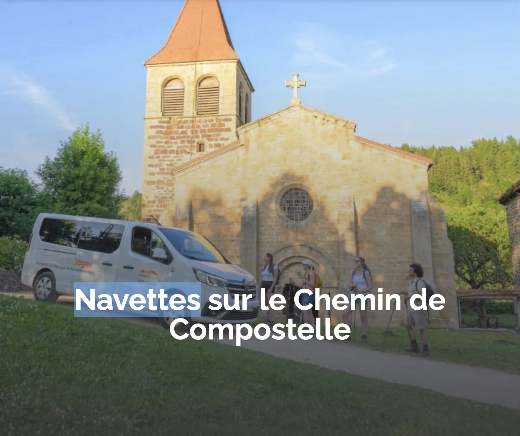 Small group of people with hiking sticks standing outside an old stone church, with a white shuttle bus nearby, in a green rural setting, during daytime.