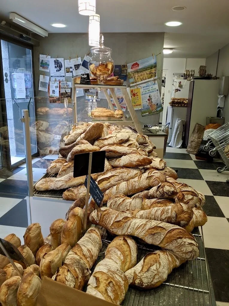 Display of various bread and baked goods in a bakery shop.