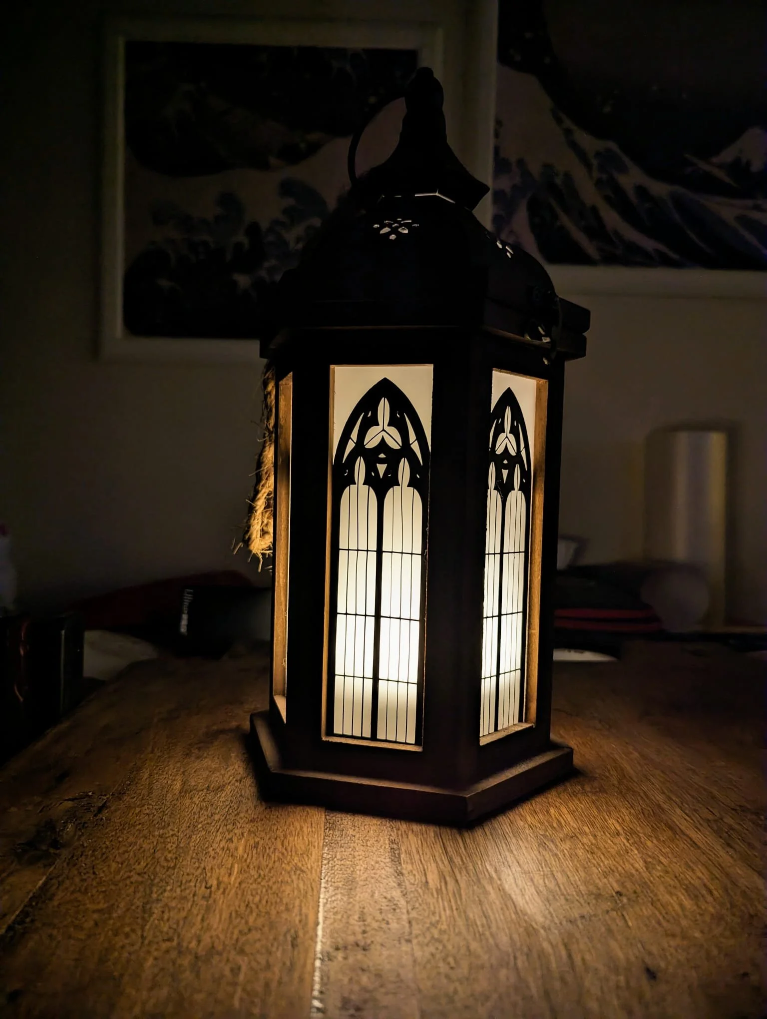 Eine Vintage-Laterne mit beleuchtetem Glas auf einem Holztisch in einem dunklen Raum.