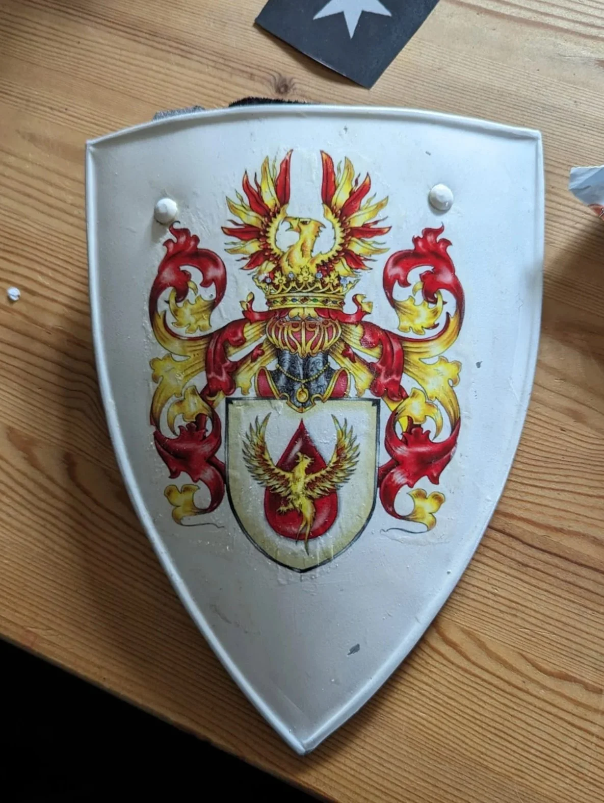 Wappenschild mit einem goldenen Doppeladler auf einem rot-weißem Schild, umgeben von einer prunkvollen Heraldik mit roten, goldenen und schwarzen Elementen.