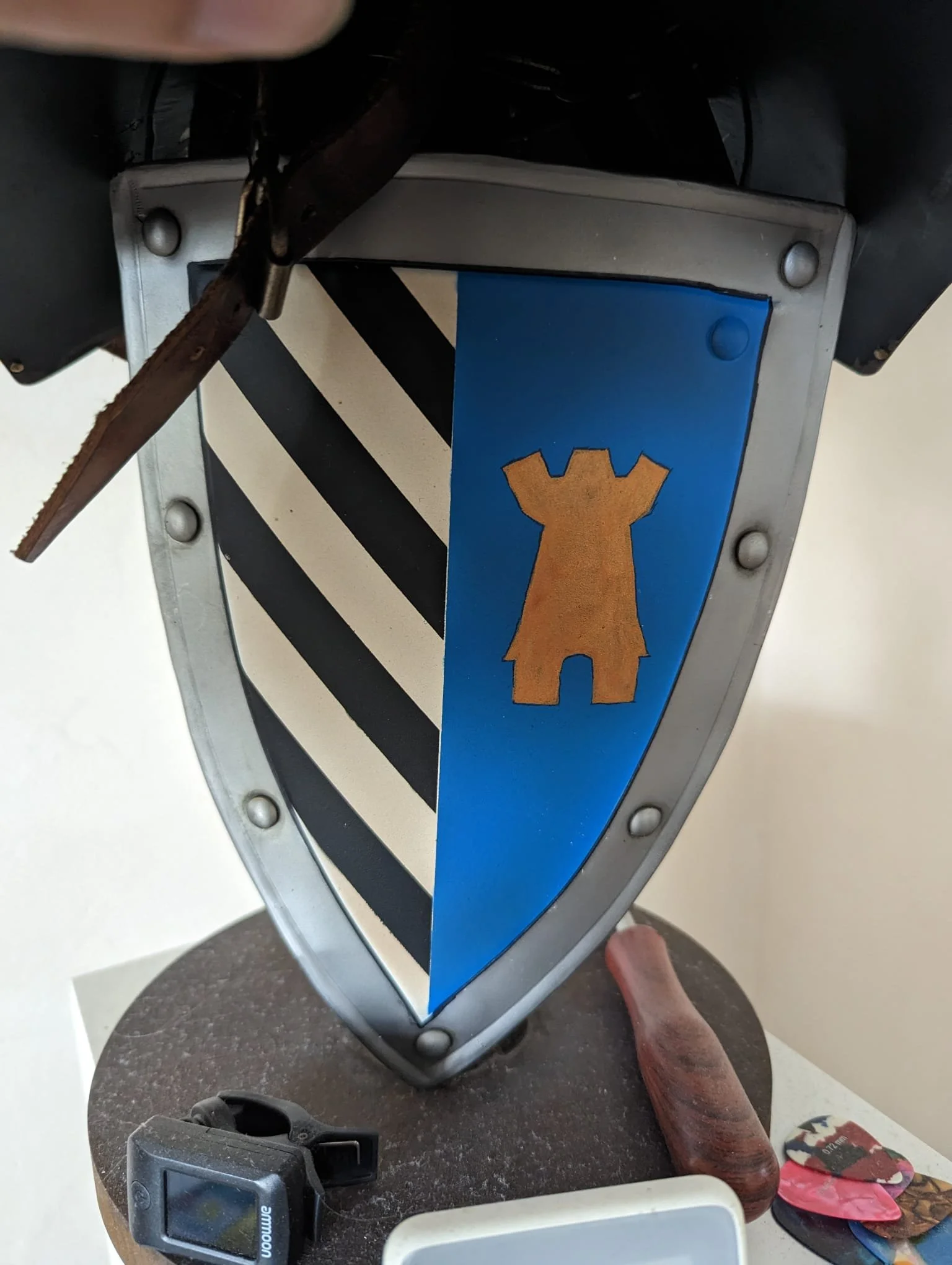 Wappenschild mit schwarzen und weißen Diagonalisolen und einem blauen Feld mit einem goldenen Ritterrock.