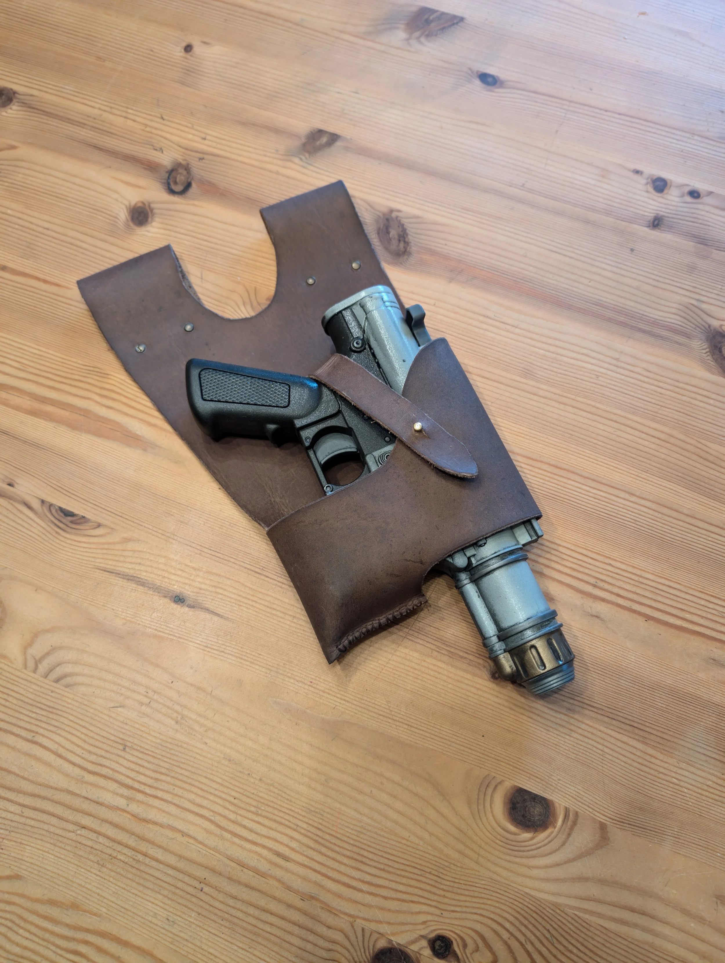 Eine Pistole in einer braunen Lederschaft, die in einem Holster liegt.