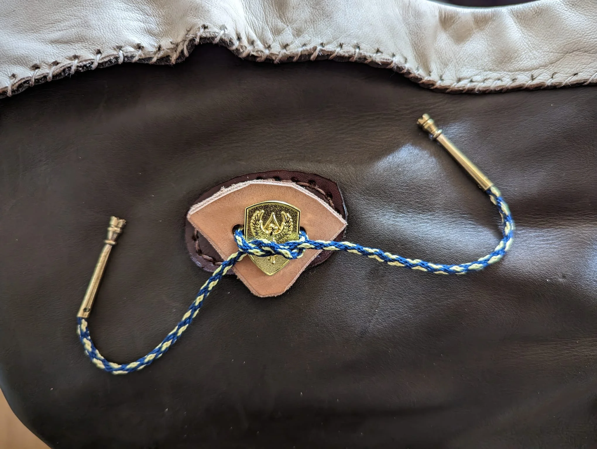 Hauptschirm mit Gold-Abzeichen, braunes und schwarzes Leder, schwarzes und heller Stoff