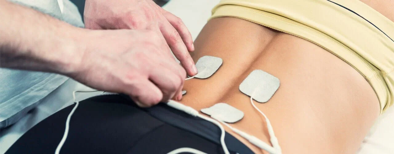 A person receiving an electrocardiogram (EKG) with several electrodes attached to their chest.