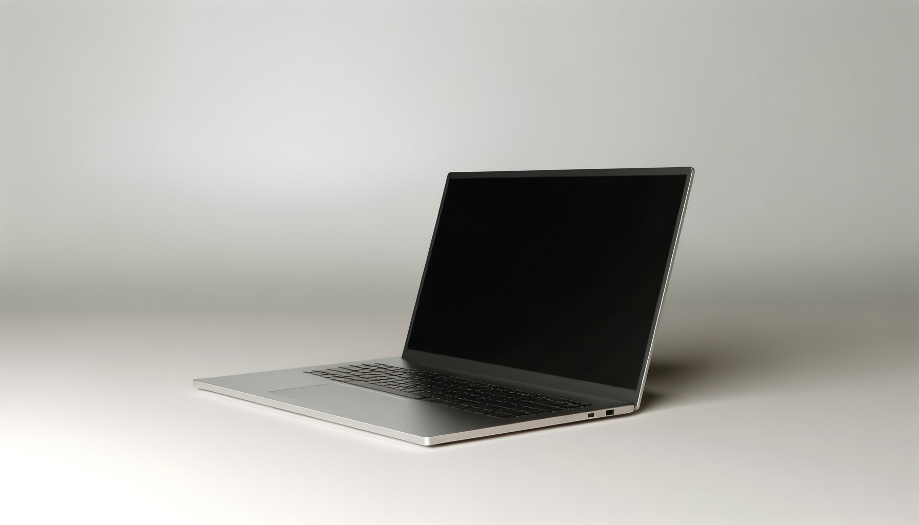 Silver laptop with black keyboard on a plain white surface and background.