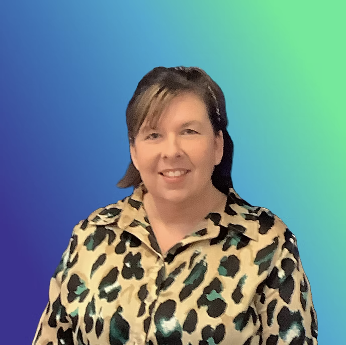 A woman with short brown hair smiling, wearing a leopard print shirt, standing against a blue-green gradient background.