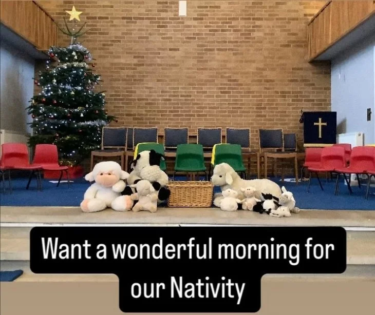 Decorated Christmas tree with plush toys, chairs, and a basket on stage, with a caption saying 'Want a wonderful morning for our Nativity.'