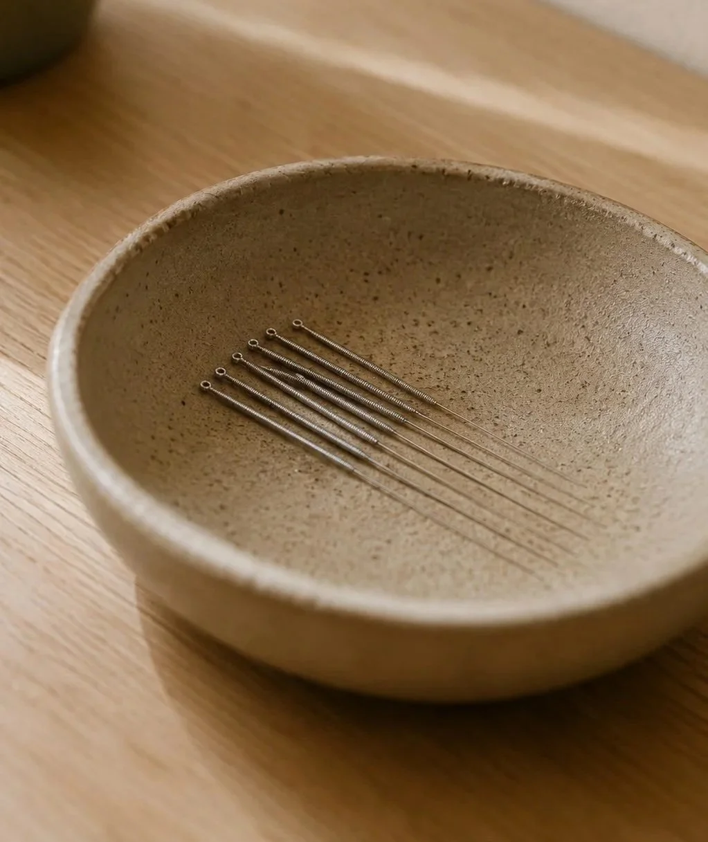Needles resting on a brown ceramic bowl.