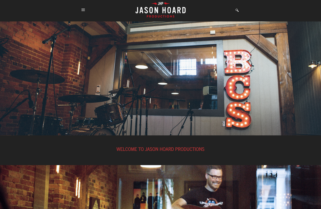 Interior of Jason Hoard Productions with a drum set and a neon sign that says "BCS."