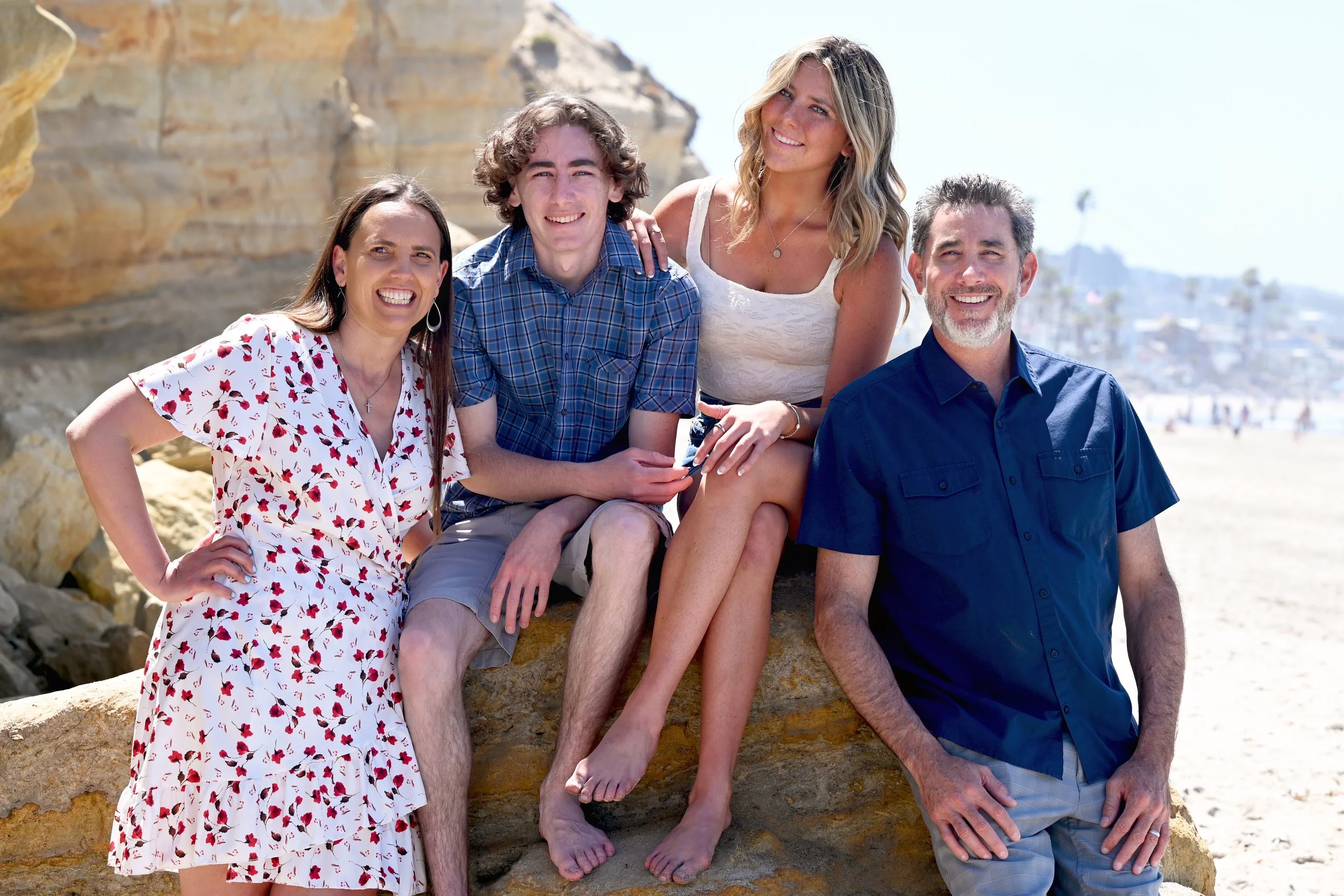 A blended family posing on the beach for a family portrait.