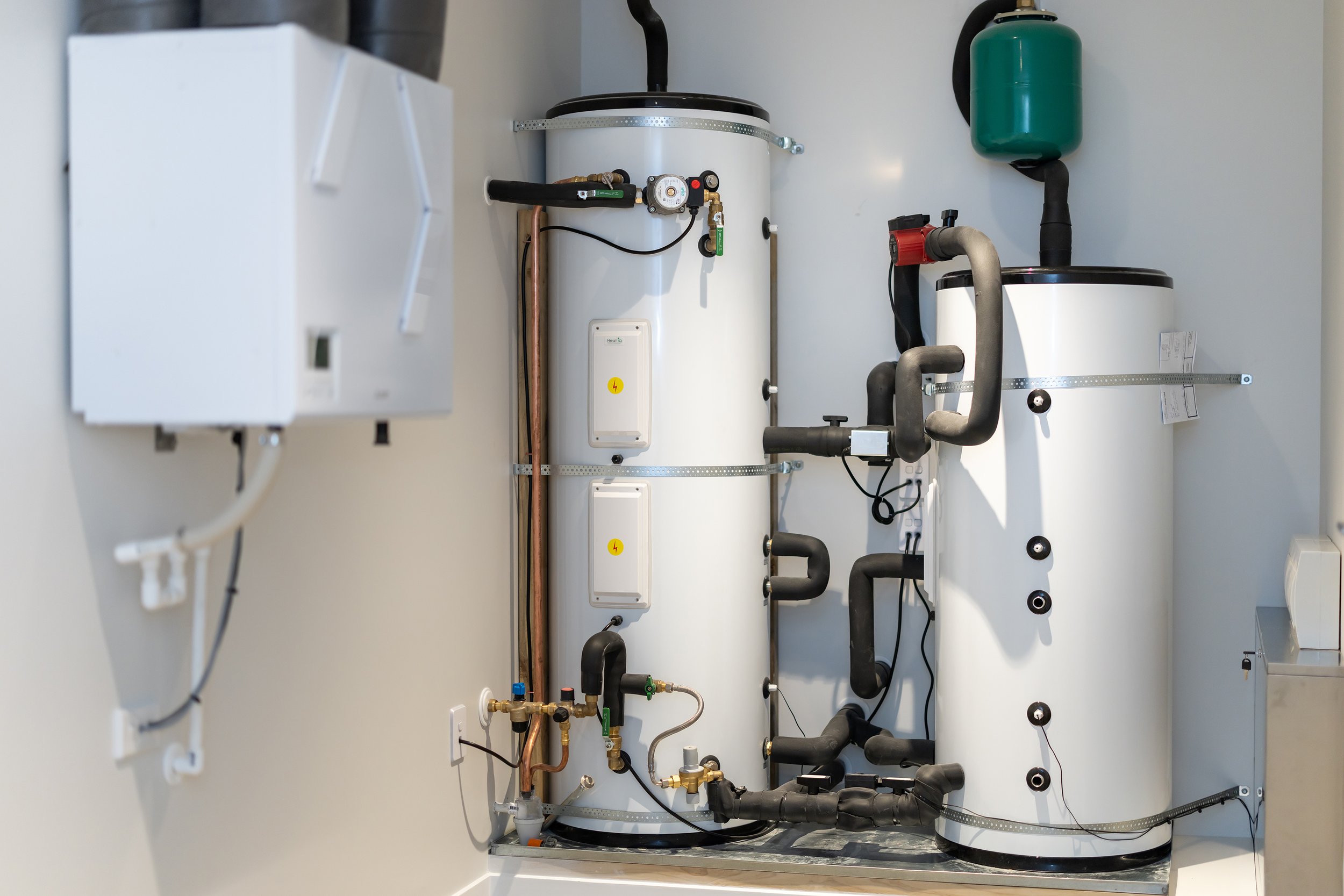 Image of a hot water heater system with pipes, valves, and control units installed in a utility room.
