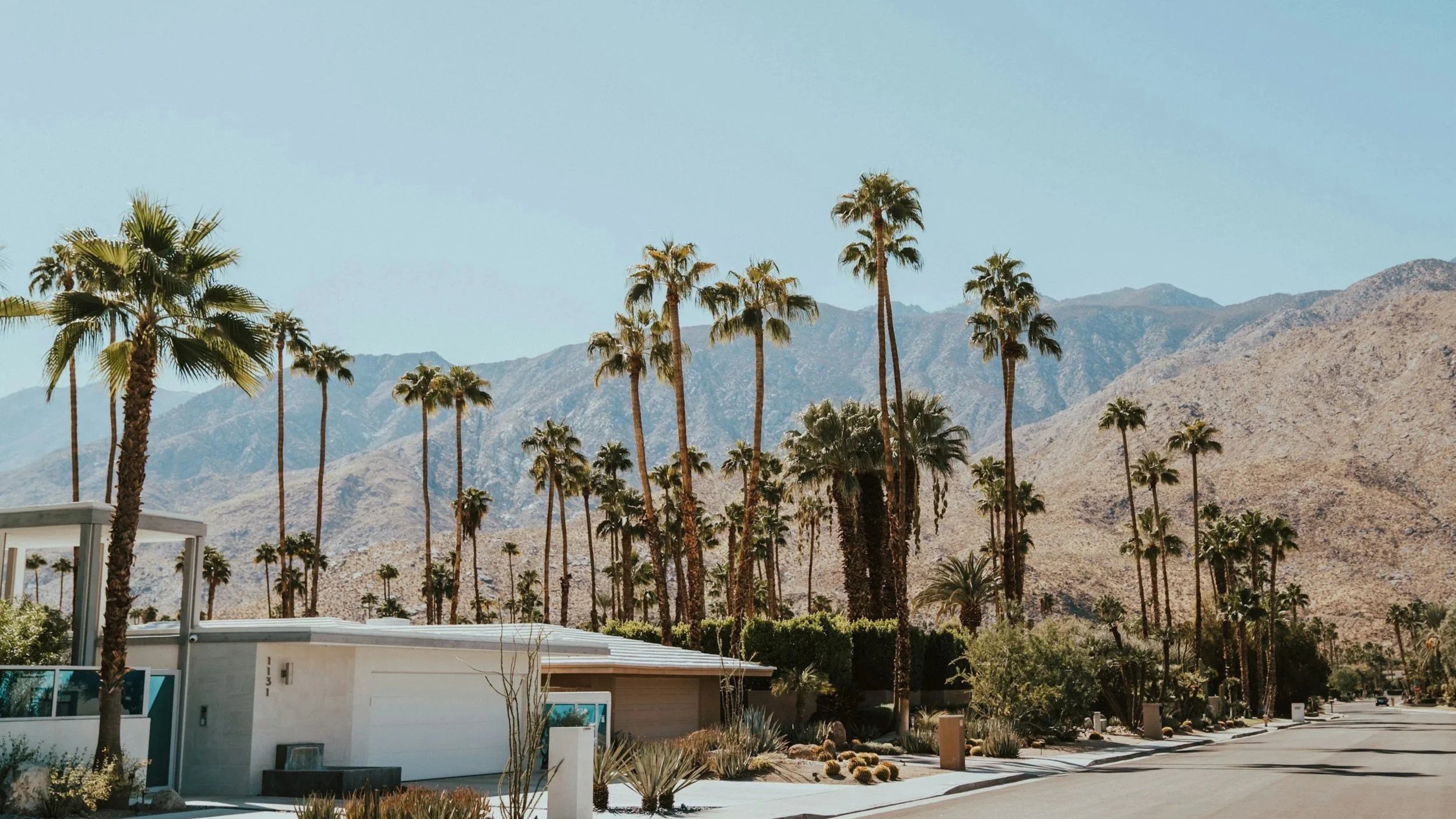 A residential street with mountains in the background in Palm Springs California.