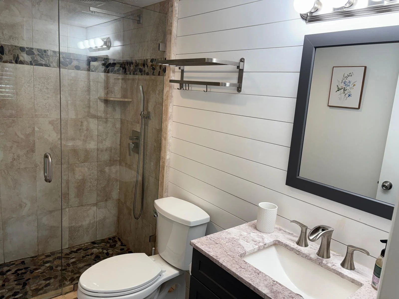 Bathroom with walk-in shower, toilet, and vanity with mirror