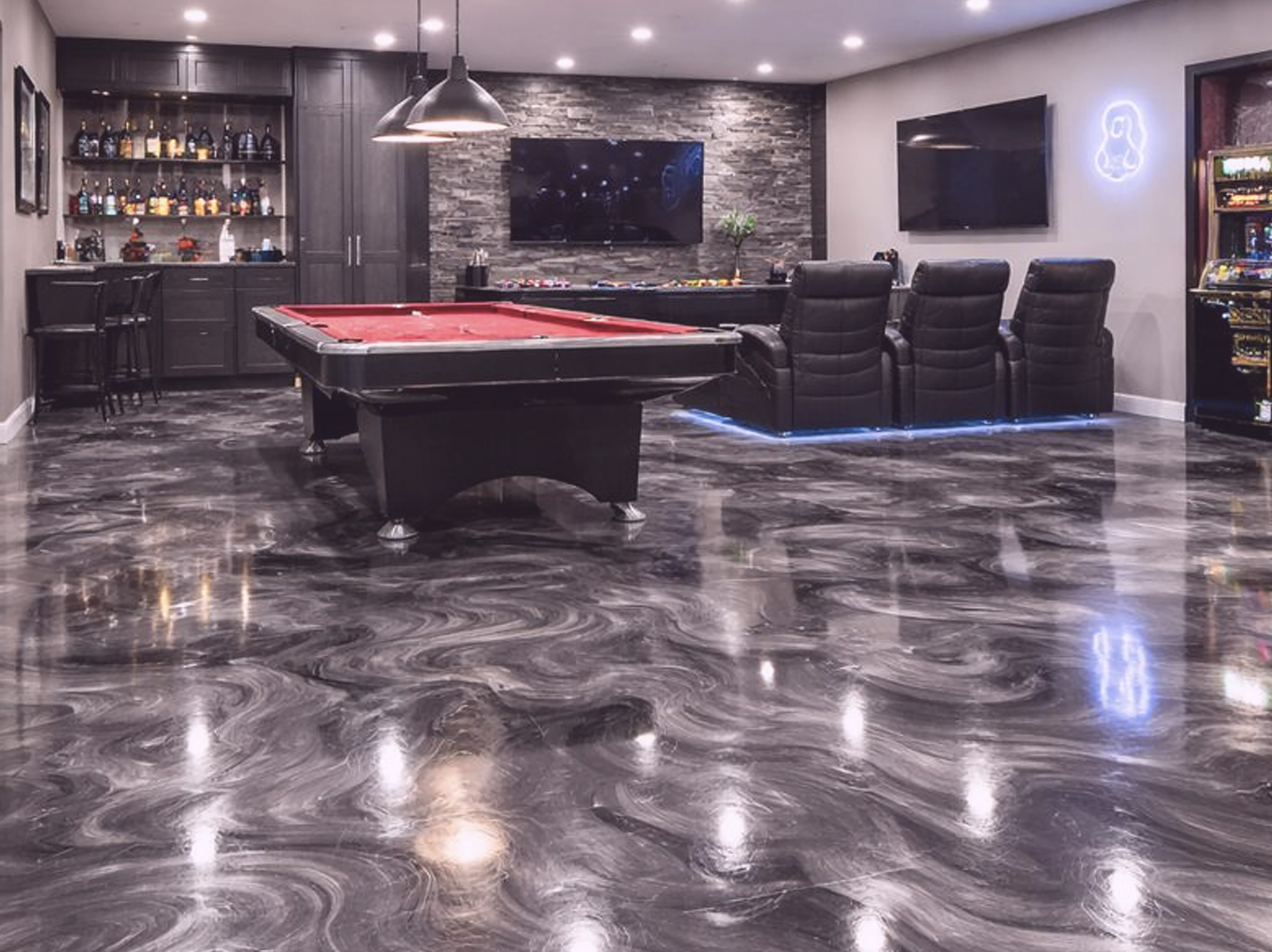 A basement game room with a shiny metallic epoxy floor remodeled.