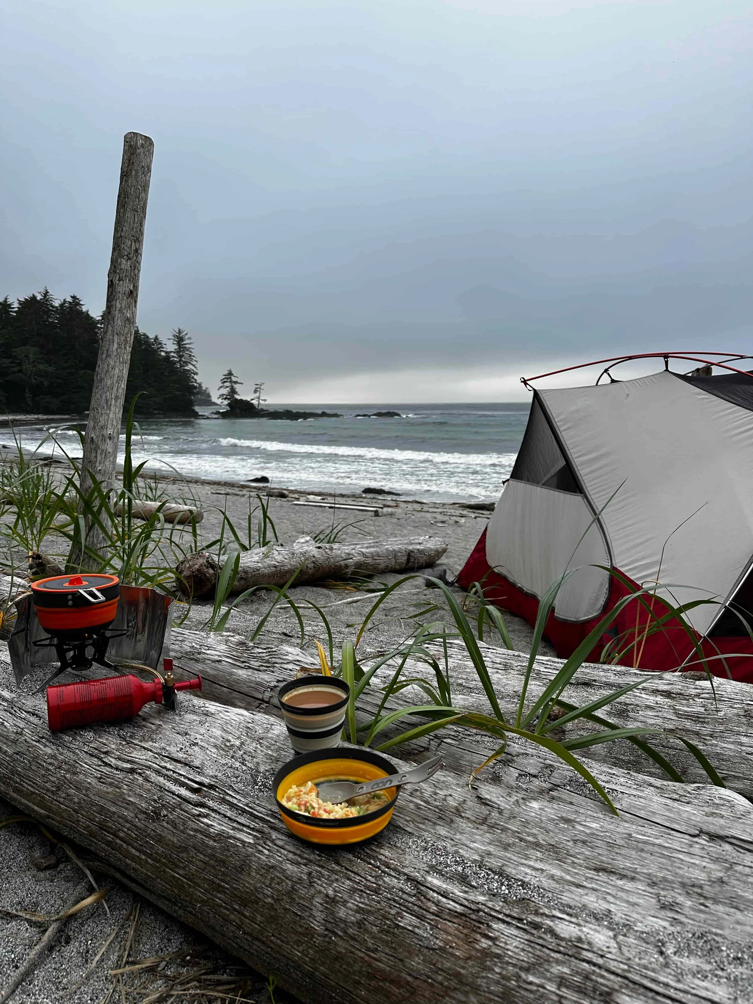 Backpacking camp and morning cooking setup on a driftwood log along the Vancouver Island coastline.